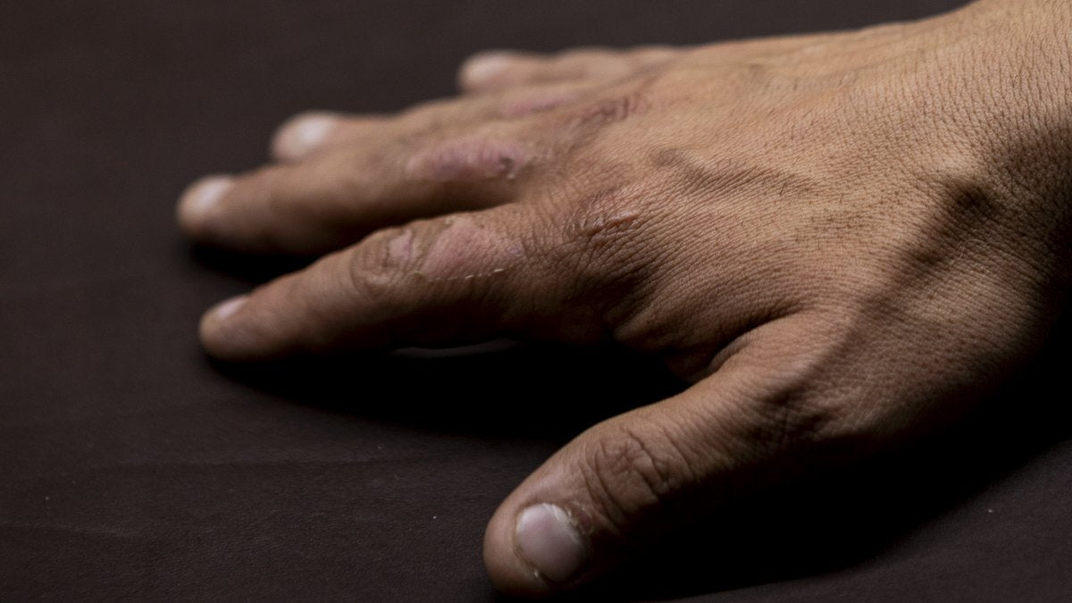 Die Hand eines Handwerkers auf Vollnarbenleder